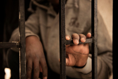 Fourteen-year-old Issaa, a migrant from Niger, rests his hand on a gate inside a detention centre, in Libya, Saturday 28 January 2017. © UNICEF/UN052682/Romenzi (CNW Group/UNICEF Canada)