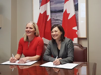 Canada's Minister of Environment and Climate Change, Catherine McKenna, and Alberta's Minister of Environment and Parks and the Minister Responsible for the Climate Change Office, Shannon Phillips, sign a memorandum of understanding to renew Canada and Alberta's commitment to ongoing monitoring of the cumulative environmental impacts of oil sands development. (CNW Group/Environment and Climate Change Canada)