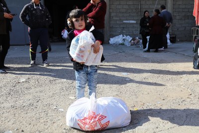Little child manages a portion of the "Christmas basket" given to persecuted Christians in Iraq by the Knights of Columbus.