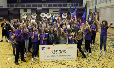 The Louisburg High School marching band members react Nov. 28 after receiving a $25,000 check. Cheerios, as part of its Moments of Good program with Walmart, surprised the band leader John Cisetti (front left) and his band at an all-school assembly to help them meet their fundraising goal for the band’s first-ever trip to the Rose Parade.