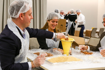 OppenheimerFunds employees pack meal kits for families affected by recent hurricanes during a volunteer event with Trusted World.
