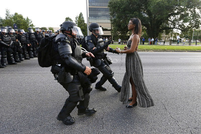 Protester Ieshia Evans stands firm as Louisiana State troopers in riot gear rush toward her during a 2016 Black Lives Matter protest in Baton Rouge, La. She was arrested for obstructing a highway. The photo went viral and became a symbol of the continuing struggle for civil rights for all Americans. Credit: Jonathan Bachman, Reuters
