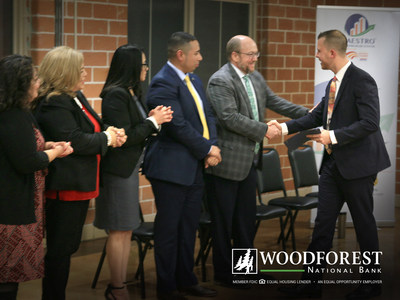 Representatives from Woodforest National Bank and Maestro Entrepreneurship Center congratulating cohort graduates.