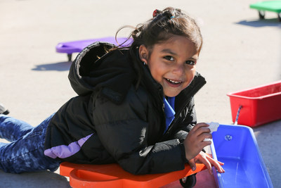 Student at Valverde Elementary School plays outside in her new coat after Operation Warm and Hollister Co. coat giving event.