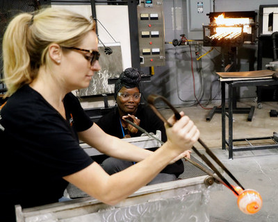 An expert glassblowing, called a "Gaffer," provides a hands-on lesson to a wounded warrior.