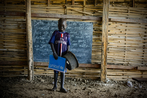 Au site de protection des civils de Bentiu, dans l’État d'Unité, dans le nord du Soudan du Sud, Maet, 6 ans, apporte avec une vieille casserole trouée afin de pouvoir s’asseoir durant les cours. © UNICEF/UN030146/Rich (Groupe CNW/UNICEF Canada)