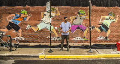 Hebru Brantley standing in front of his mural of the Flyboy character. Credit: Rocky Russell