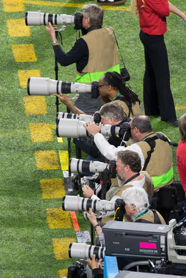 Canon's iconic white EF lenses and DSLR cameras alongside the sideline at The Big Game in Minnesota.