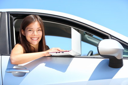 Laptop woman in car on internet outside. Smiling young woman using computer netbook outdoors. Asian Caucasian female professional.