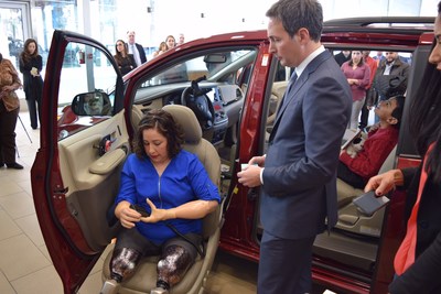Amanda Flores (left) tries out features of the mobility van donated by DARCARS CEO, John Darvish (right)