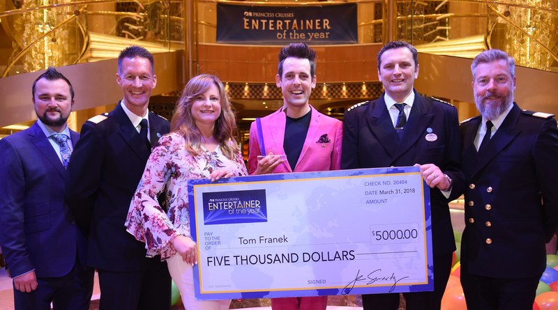 Tom Franek (center), voted 2018 Entertainer of the Year by Princess Cruises guests. Denis Saviss, vice president of entertainment experience for Princess Cruises and members of the Regal Princess entertainment staff were on-hand to present the check.