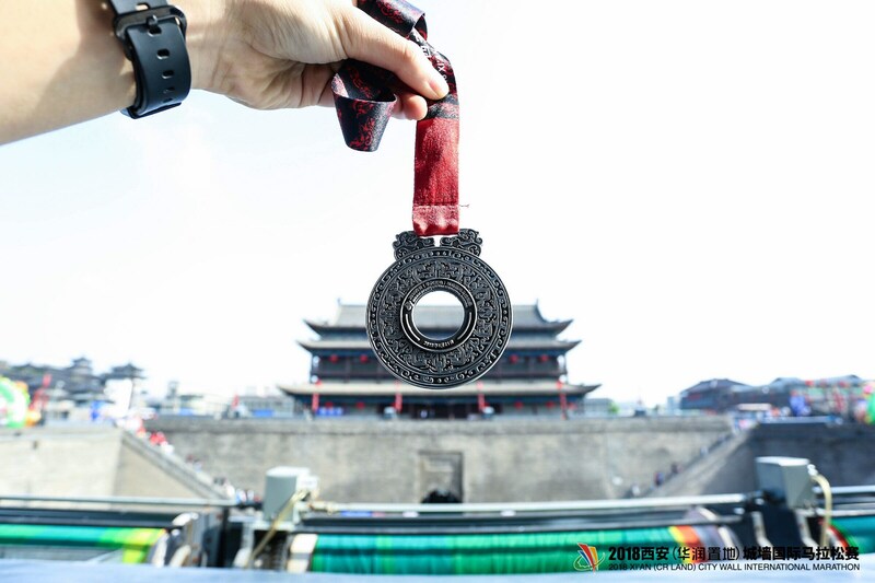 Medalla de la Maratón Internacional de Xi'an 2018 en forma de jade de la dinastía Han occidental de la antigua China. (PRNewsfoto/Xi'an International City Wall M)