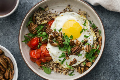 Spiced pecans are combined with hearty quinoa and roasted grape tomatoes and then topped with a fried egg for a flavorful and vegetarian-friendly breakfast bowl.