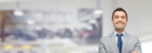 Happy and smiling car salesman