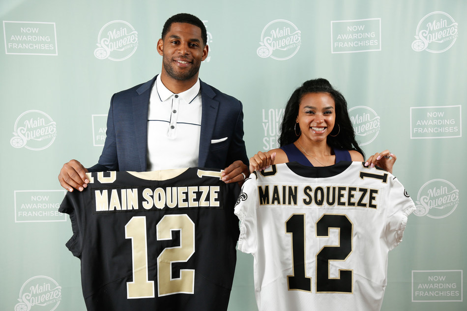 Marques Colston holding a jersey that says Main Squeeze