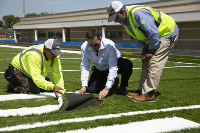 Reed J. Seaton, president and CEO of Hellas Construction, works with Salvador Martinez and Superintendent Saleh Khan to inlay yardage numbers on a Hellas Matrix® Helix field with Cushdrain® pad being installed at Dement Field in Galena Park, Texas today. Seaton is a 2018 finalist for the Entrepreneur Of The Year in the Central Texas Region.