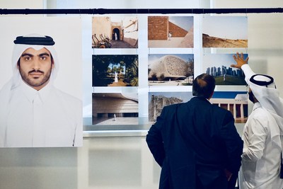 Qatari photographer Khalid Al Hammadi discusses his work with a guest at the opening reception of 