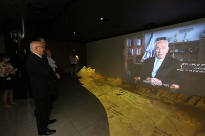 Mike Evans and President Rivlin looking at the video of late 9th President Shimon Peres
