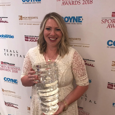 Phoenix Suns fan Whitney Collins poses with the Best in Mobile Fan Experience trophy won by 15 Seconds of Fame at the 2018 Sports Business Awards in New York City.