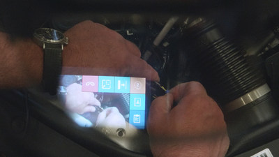Tech Live Look - Computer menu visible to on-site technician wearing smartglasses while working on engine.