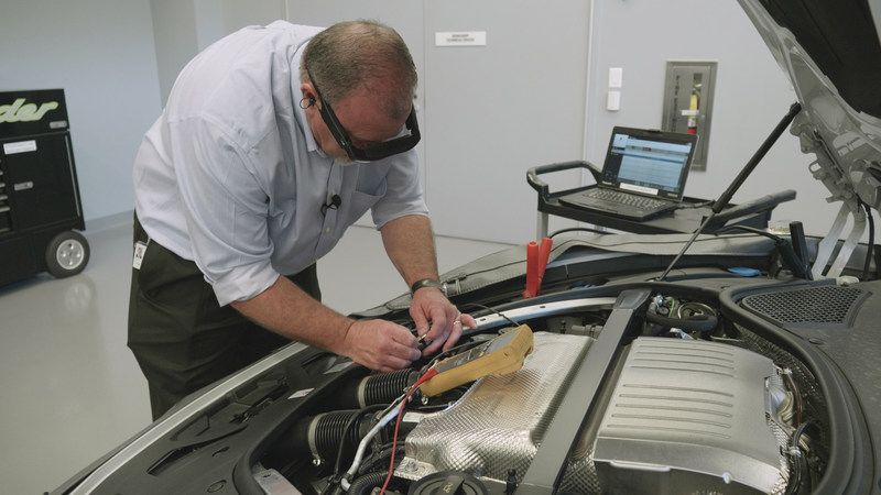 Tech Live Look - On-site technician works on engine while interacting with remote expert via smartglasses.