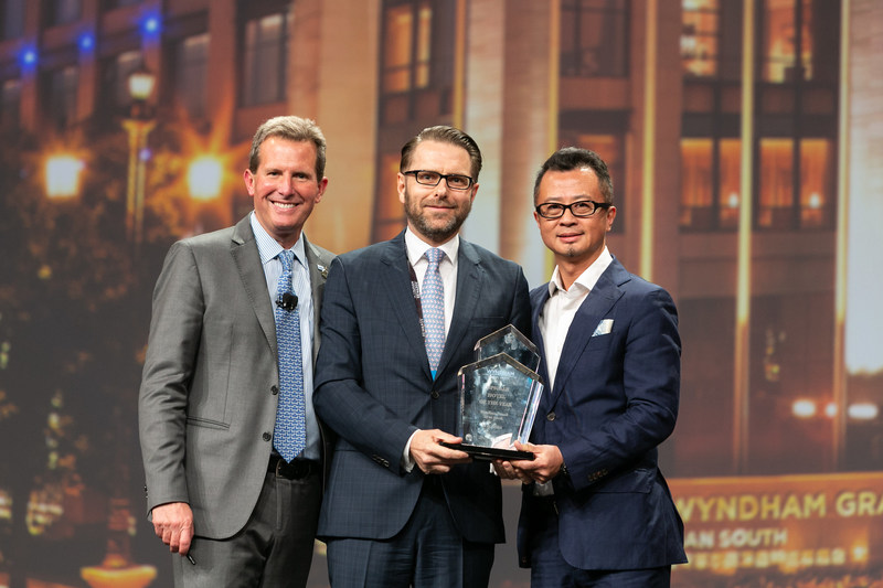 Geoff Ballotti (left), the President and CEO of Wyndham Hotel Group, revealed the winner and presented the trophy to Frank Rudis (middle), the General Manager of Wyndham Grand Xi'an South, and Leo Liu (right), the President and China MD of Wyndham Hotel Group." border="0" alt="Geoff Ballotti (left), the President and CEO of Wyndham Hotel Group, revealed the winner and presented the trophy to Frank Rudis (middle), the General Manager of Wyndham Grand Xi'an South, and Leo Liu (right), the President and China MD of Wyndham Hotel Group.