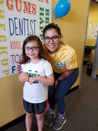 A child and volunteer staff member from Kool Smiles were all smiles during their annual free care day.