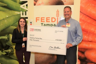 Darren Fredericks, general manager, BJ's Wholesale Club in Tampa (right) presents a $50,000 donation from the BJ's Charitable Foundation to Kat Agresta, procurement manager, Feeding Tampa Bay (left) to support their Hunger-Free Summer Programs.
