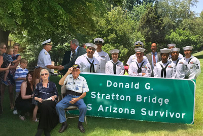 Don Stratton, survivor of Pearl Harbor's USS Arizona takes in the newly named Interstate 25 /Fillmore Bridge sign presented to him by the Pikes Peak Heroes Legacy Committee during a ceremonial dedication at Holiday Village in Colorado Springs. (Photo courtesy of Holiday Village)