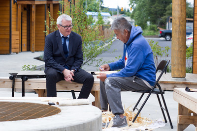 Adam Vaughan, Parliamentary Secretary to the Minister of Families, Children and Social Development and Charles George, an artist and wood carver who lives at Nuutsumuut Lelum. Photo: Gabriel Teo, CMHC. (CNW Group/Canada Mortgage and Housing Corporation)