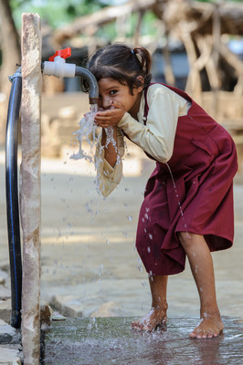 A young girl drinks clean water from a hand pump now available in Mahadev Pura village, Madhya Pradesh, India. Through a WaterAid project, all local homes now have toilets and handwashing is regularly practiced, greatly reducing the rate of illness, especially among women and children. (WaterAid/ James McCauley)