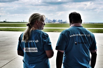 #hackinthehangar attendees from Microsoft and HootSuite look out at the Calgary skyline from the WestJet hangar (CNW Group/WESTJET, an Alberta Partnership)