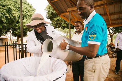 Uzo Aduba & William Matovu collect milk at the East Africa Dairy Development project in Dwaniro, Uganda.