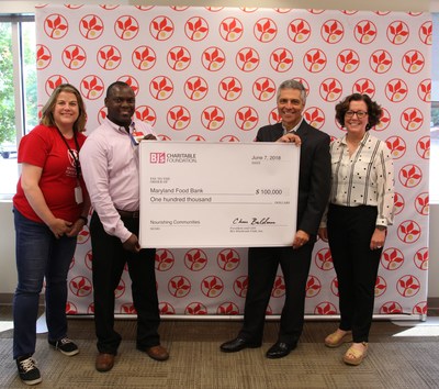 Sicone McLean, general manager, BJ's Wholesale Club in Columbia (second from left) presents a $100,000 donation from the BJ's Charitable Foundation to Carmen Del Guercio, President & CEO, Maryland Food Bank (second from right) to support their Hunger-Free Summer Programs.