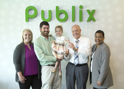 Ashley and Ryan Bahr (left) with their 3-year-old daughter, Presley, join March of Dimes President Stacey D. Stewart (far right) to present Publix Super Markets, Inc. CEO and President Todd Jones the Crystal Award for being the #1 March for Babies Corporate Partner. Presley was featured on paper 