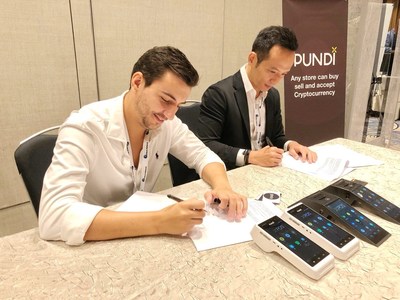 Pundi X CEO and co-founder Zac Cheah and UTRUST CEO Nuno Correia sign an agreement in Singapore on Wednesday.