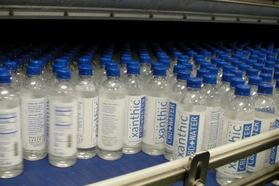 Pictured above: A shot of Xanthic CBD Water bottles exiting the dryer before packaging for shipment. (CNW Group/Xanthic BioPharma)