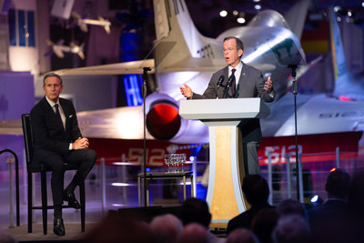 Admiral Michael Mullen (ret.), (pictured right at podium aboard the USS Intrepid in New York) introduces Starbucks Chairman Emeritus Howard Schultz (seated left). Mullen and Schultz spoke at a recent fundraiser for the National WW1 Memorial in Washington, D.C. aboard the USS Intrepid. Now the public is invited to hear their remarks in an exclusive episode (#77) of the award-winning WW1 Centennial News Podcast