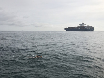 In addition to cold rough water and challenging currents, the English Channel is also a major maritime shipping lane with large tankers and boats plying their way up and down the coasts of England and France. Here Bergman is in the foreground while a tanker heads north. She completed her swim in 13 hours 15 minutes.
