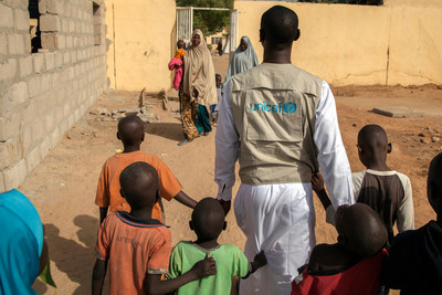 En novembre 2016, un spcialiste de la protection de l'enfance  l'UNICEF marche avec des enfants, au centre de transit de Maiduguri, dans l'tat de Borno, au Nigria  UNICEF/UN038572/Naftalin (Groupe CNW/UNICEF Canada)
