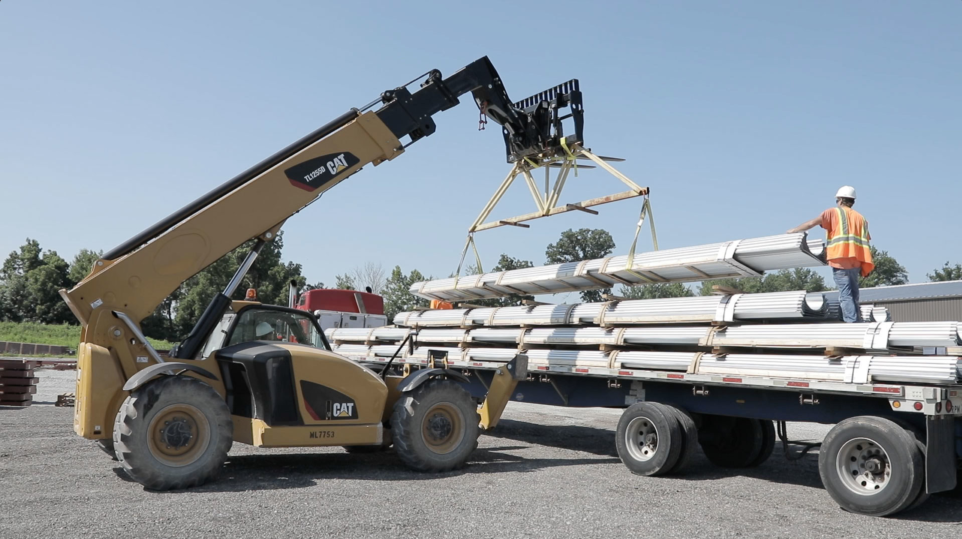Ten trucks deliver steel I beams for the construction of the facility expansion