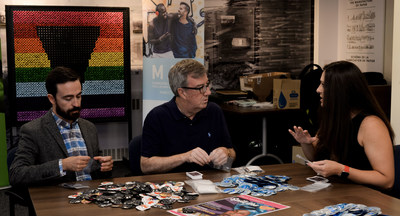 Roberto Ortiz, Executive Director of MAX Ottawa, Mayor Jim Watson, and Sara Leclerc, General Manager at ViiV Healthcare Canada, prepare condom kits for use by MAX at Pride and Spill the Tea events. (CNW Group/MAX Ottawa)