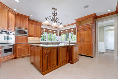 An open kitchen with a large island and top-of-the-line appliances is perfect for the suburban chef. Discover more at ConnecticutLuxuryAuction.com.