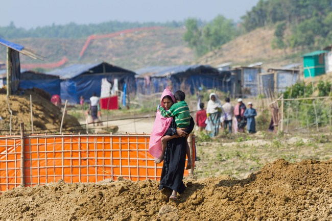 A Rohingya woman and her child walk towards Hope Field Hospital For Women in Madhuchara camp on January 18, 2018, in Cox's Bazar, Bangladesh. (Photo by Rajib Dhar for Direct Relief)