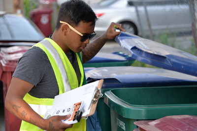 Recycling partner Bora Chhun in Lowell, Massachusetts inspects a recycling cart to provide feedback directly to residents about how to recycle more and recycle better. A survey of Massachusetts residents revealed that people wanted to recycle but needed clarity on proper recycling practices, which The Recycling Partnership provided.
