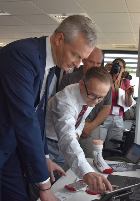 Keith Planner, Palarum, LLC's European Representative, explains the PUP smart patient sock technology to Bruno Le Maire, France's Minister of the Economy, at Texisense, the French company that developed the fabric pressure sensors and leads.
