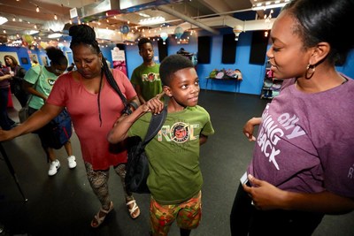 Ally employee volunteers hand out backpacks full of school supplies to help Detroit children get ready for the new school year on August 21, 2018. Ally volunteers helped distributed more than 800 backpacks full of supplies, uniforms, and hygiene products at The Children's Center's Back to School Bazaar which helps prepare students to kick off the school year with the necessary items.