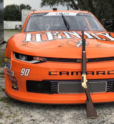 The bright orange car is fully wrapped in a livery for Henry Repeating Arms, a firearms manufacturer well-known for their lever action rifles.