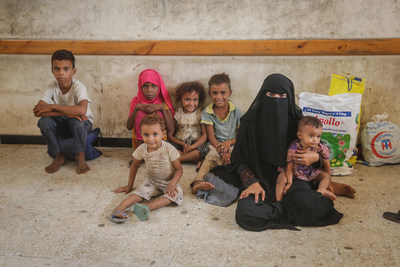 Le 30 juin 2018, une femme et des enfants attendent, lors d'une distribution de fournitures essentielles  la survie soutenue par l'UNICEF,  Hodeidah, au Ymen. (c) UNICEF/UN0219932 (Groupe CNW/UNICEF Canada)