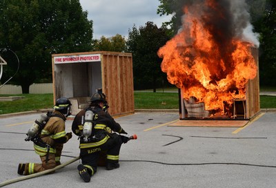 Side-by-side fire demonstration.  One unit is protected with a fire sprinkler system, the other unit is not.